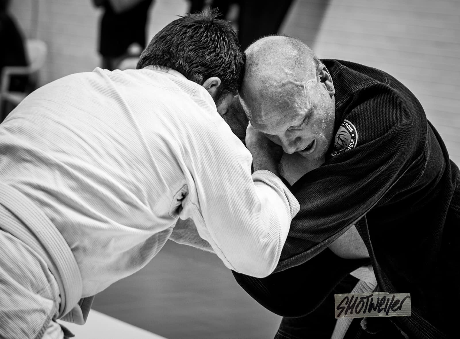 Two man wrestling in a Gi BJJ Competition